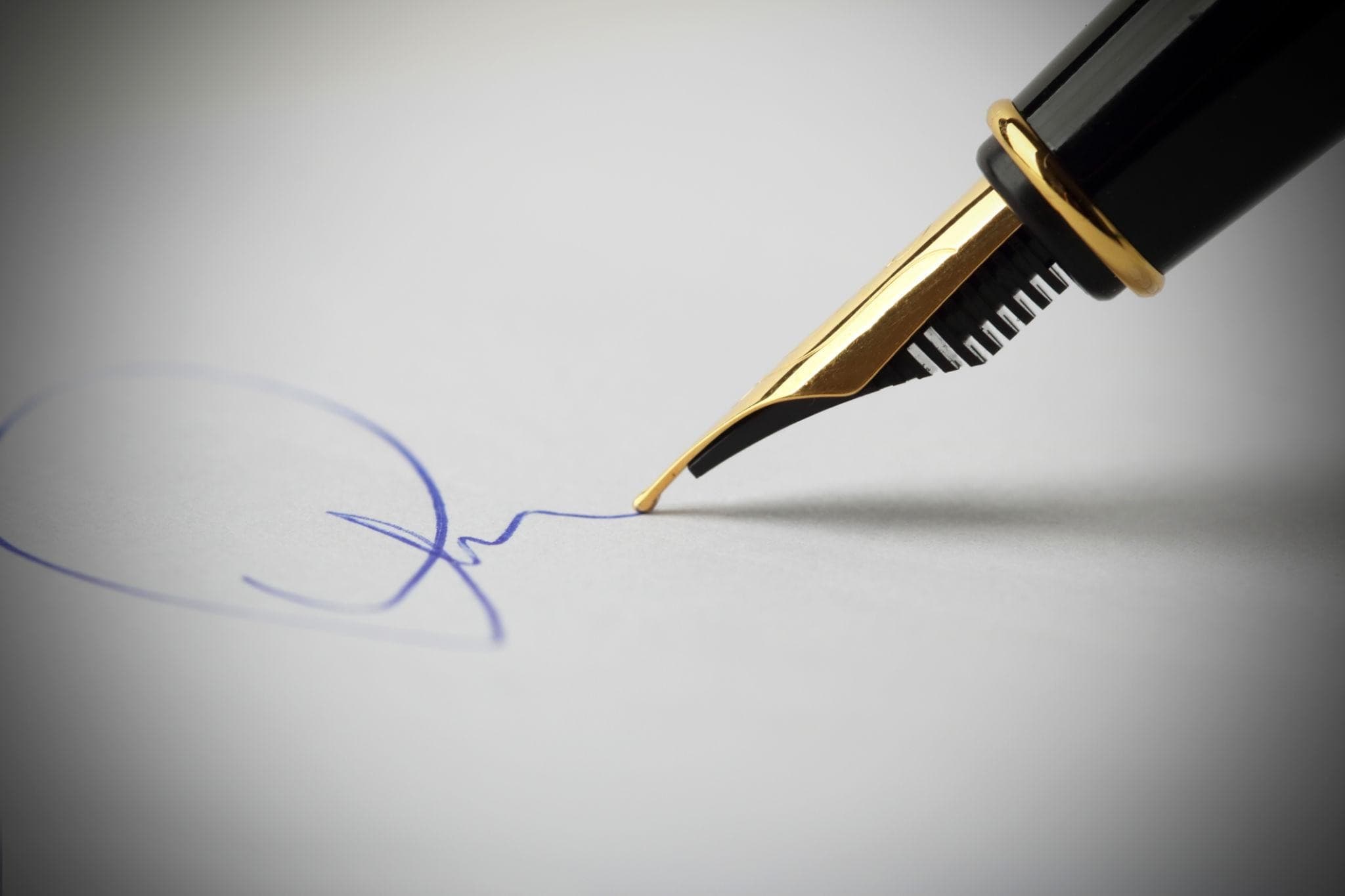Close-up of a fountain pen signing a document